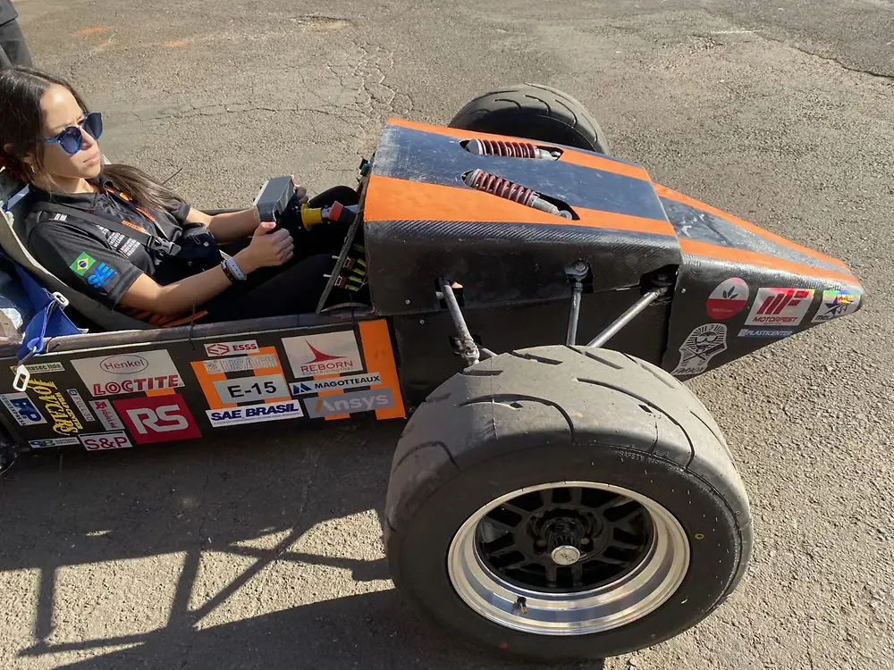 estudiante mujer probando el auto eléctrico en pista